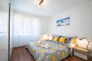 ein Schlafzimmer mit einem Bett mit gelben und grauen Kissen in der Unterkunft Castropola Apartment in Pula