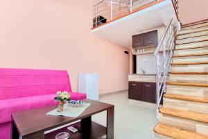 - un salon avec un canapé rose et une table dans l'établissement Apartments Porto Bjelila, à Tivat