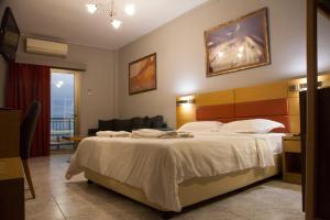 
a hotel room with a bed, chair, and nightstand at Hotel Erika in Alexandroupoli
