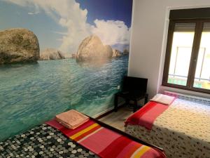 レオンにあるIdeal Grupos Grandes Barrio Húmedoの海の壁画とベッド2台が備わるベッドルーム1室が備わります。