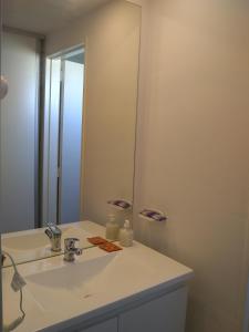 y baño con lavabo blanco y espejo. en Pasco 1847 Apartamento 5B en Rosario