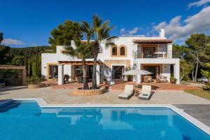 a villa with a swimming pool in front of a house at Villa Arcadia in Ibiza Town