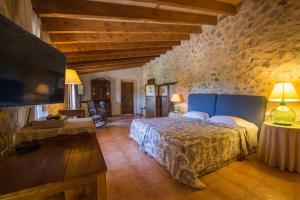 a bedroom with a large bed and a tv at Agroturismo Can Feliu in Porreres