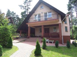 a house with a balcony and a patio at Holiday Home Mielno 2 by Interhome in Mielno
