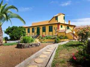 una casa amarilla con una palmera delante de ella en Holiday Home Camino La Candelaria-2 by Interhome, en La Orotava