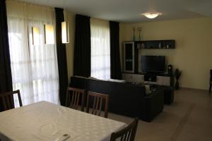 a living room with a table and a television at Sani Holiday Village in Sozopol