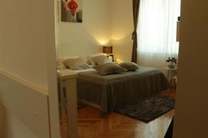a bedroom with a bed with a desk and a window at Downtown Main Street Studio in Zadar