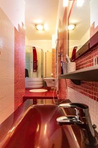 baño con lavabo y pared de azulejos rojos en Villa Neraida, en Neráïdha