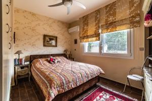 a bedroom with a bed with a teddy bear on it at Villa Neraida - Panoramic Lake View Retreat in Neráïdha