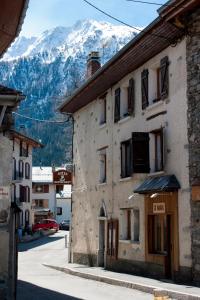 un bâtiment dans une rue avec une montagne en arrière-plan dans l'établissement Chalet Hotel La Tarine, à Peisey-Nancroix