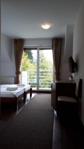 een kamer met een bed en een groot raam bij Apartamenty Panorama in Rychwałd