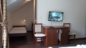 een kamer met een bureau en stoelen en een televisie bij Apartamenty Panorama in Rychwałd