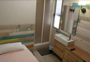 a bathroom with a bed and a sink and a mirror at Pensión Fortea in Zaragoza