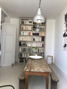 a room with a wooden table in front of a book shelf at l'autre maison in Penne-dʼAgenais