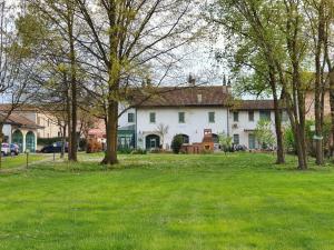 a large white house with trees in a yard at B&B La Borasca - Rooms in Casalpusterlengo