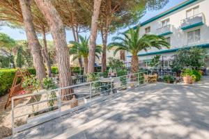 a resort with palm trees and a building at Hotel Massimo in Marina di Cecina