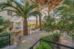 a balcony with palm trees and a table and chairs at Hotel Massimo in Marina di Cecina