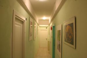 un pasillo con paredes verdes y blancas y una puerta blanca en Colosseoinn, en Roma