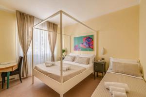 um quarto com uma cama de dossel e uma secretária. em Hotel Massimo em Marina di Cecina
