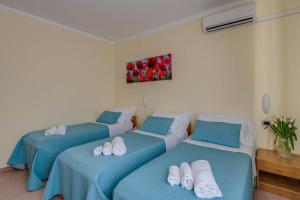 two beds in a room with blue and white at Hotel Massimo in Marina di Cecina