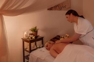 a woman is giving a man a massage at Hotel Massimo in Marina di Cecina