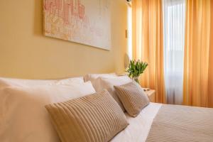 a bedroom with a white bed with two pillows at Hotel Massimo in Marina di Cecina