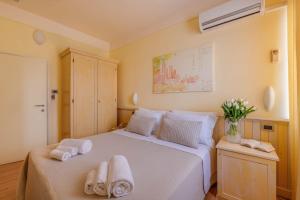 a bedroom with a white bed with towels on it at Hotel Massimo in Marina di Cecina