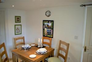Chatton的住宿－Cuddy's Croft，餐桌和椅子,墙上挂着时钟