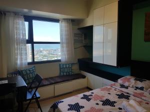 a bedroom with a bed and a window at Hermione's Haven at Horizon 101 Cebu in Cebu City