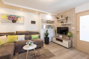 a living room with a couch and a tv at Holiday Home Punat in Punat