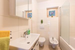 a white bathroom with a sink and a toilet at Holiday Home Punat in Punat +35 photos