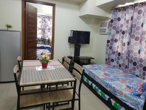 een kleine kamer met een tafel en een bed en een tafel en stoelen bij KC 1-Bedroom 1 at Horizon 101 Cebu in Cebu City
