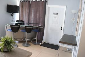 Habitación con mesa, sillas y puerta en Ocean Mile Hotel, en Fort Lauderdale