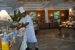 a chef preparing food at a buffet in a restaurant at Lanka Princess All Inclusive Hotel in Bentota