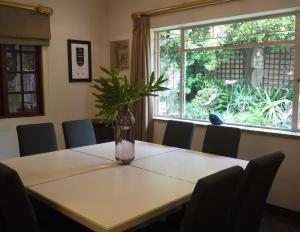 une table avec un vase avec une plante sur elle dans l'établissement Claires of Sandton Luxury Guest House, à Johannesbourg