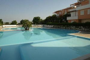 a large blue swimming pool next to a building at Tramonti Residence in Sant'Isidoro
