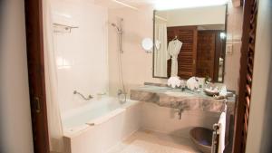a bathroom with a tub and a sink and a bath tub at Lanka Princess All Inclusive Hotel in Bentota