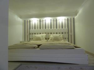 een slaapkamer met een groot bed met verlichting bij Kossuth Apartmanok in Debrecen