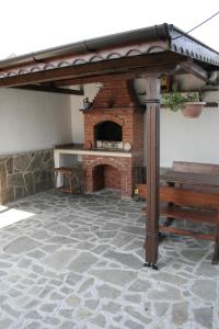 a stone patio with a brick fireplace with awning at Sani Holiday Village in Sozopol