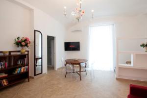 a living room with a table and a chandelier at Casa Sorrentina in Sorrento