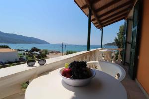 a bowl of fruit sitting on a table on a balcony at House Dimitri Agios Georgios Pagoi Corfu in Agios Georgios Pagon