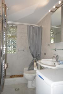 un bagno bianco con lavandino e WC di Varkiza's Cottages a Varkiza Altre 54 foto