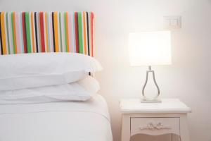 a bed with a table with a lamp on it at Casa Sorrentina in Sorrento