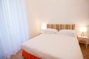 a bedroom with a large white bed with two lamps at Casa Sorrentina in Sorrento