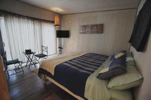 ein Schlafzimmer mit einem großen Bett in einem Zimmer in der Unterkunft El Jardin, Eco Cabañas Boutique in San Alfonso