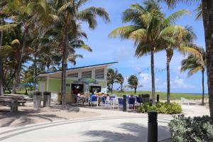 ein Restaurant am Strand mit Palmen in der Unterkunft Ocean Mile Hotel in Fort Lauderdale