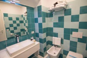 a bathroom with a green and white tiled wall at Casa Sorrentina in Sorrento