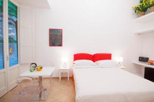 a white bedroom with a bed and a table at Casa Sorrentina in Sorrento