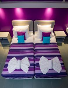 a bedroom with two beds dressed in bow ties at Kahlua Hotel Apartments in Rhodes Town