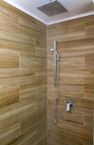 a bathroom with a shower with wooden tiles at Kahlua Hotel Apartments in Rhodes Town